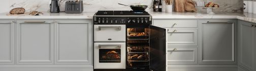 A 90cm range cooker with the right hand oven door open, revealing 2 cavities with different dishes cooking