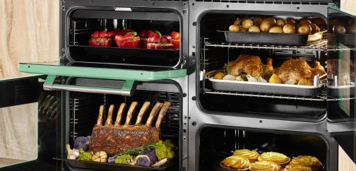 A 110cm range cooker with the doors of all 4 ovens open revealing different dishes cooking in each cavity