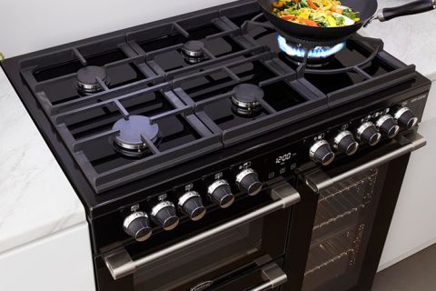 A Belling Cooktop with a stirfry cooking in a wok on a gas ring